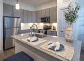 Thumbnail 2 of 34 - a kitchen with stainless steel appliances and granite counter tops