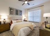Thumbnail 6 of 34 - a bedroom with a large bed and a ceiling fan