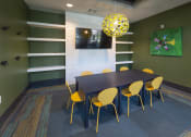 Thumbnail 19 of 34 - a dining room with a black table and yellow chairs