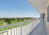 Thumbnail 29 of 31 - A balcony with a metal railing overlooks a green landscape.