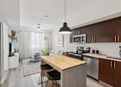 Thumbnail 20 of 31 - A modern kitchen with a wooden island and stainless steel appliances.