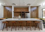 Thumbnail 5 of 31 - A modern kitchen with a long island and bar stools.