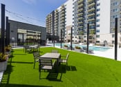 Thumbnail 30 of 37 - a large lawn with tables and chairs in front of an apartment building