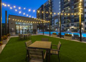Thumbnail 36 of 37 - a rendering of a yard with tables and chairs and a pool at night