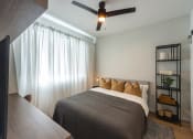 Thumbnail 9 of 37 - a bedroom with a bed and a ceiling fan