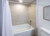 Thumbnail 12 of 37 - a bathroom with a tub and a shower and a toilet