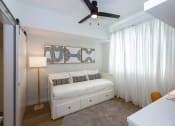Thumbnail 13 of 37 - a bedroom with a white bed and a ceiling fan