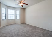 Thumbnail 7 of 30 - an empty room with a ceiling fan and three windows