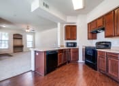 Thumbnail 1 of 30 - an empty kitchen with wooden cabinets and black appliances