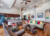 Thumbnail 15 of 30 - a living room with a kitchen and a couch and a table