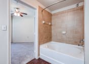 Thumbnail 11 of 30 - a bathroom with a large tub and a ceiling fan