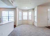 Thumbnail 6 of 30 - an empty living room with windows and a kitchen