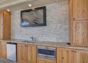 Thumbnail 18 of 26 - A kitchen with wooden cabinets and a granite countertop.