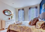 Thumbnail 4 of 26 - A bedroom with a bed, dresser, and mirror.