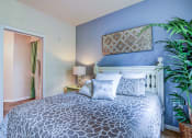 Thumbnail 3 of 26 - A bedroom with a patterned bedspread and a white bed.