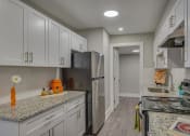 Thumbnail 5 of 36 - a kitchen with white cabinets and a stainless steel refrigerator