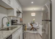 Thumbnail 6 of 36 - a kitchen with a sink and a table with chairs