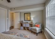 Thumbnail 10 of 36 - a bedroom with a chair and a desk with a mirror