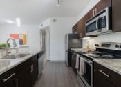 Thumbnail 7 of 36 - a kitchen with stainless steel appliances and granite counter tops and