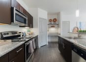 Thumbnail 8 of 36 - a kitchen with granite counter tops and stainless steel appliances