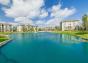 Thumbnail 32 of 36 - a large lake with apartments in the background