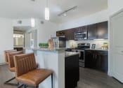 Thumbnail 6 of 36 - a kitchen with black and white appliances and a counter with chairs