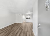 Thumbnail 15 of 38 - A room with wooden flooring and a door with a number 242 on it.