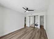 Thumbnail 24 of 38 - A room with a ceiling fan and a washer and dryer in it.