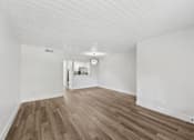 Thumbnail 13 of 38 - A room with wooden flooring and white walls.