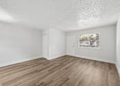 Thumbnail 16 of 38 - A room with wooden flooring and white walls.