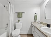 Thumbnail 35 of 38 - A white toilet sits next to a sink in a bathroom.