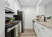 Thumbnail 11 of 38 - A kitchen with black appliances and white cabinets.