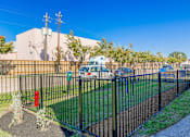 Thumbnail 29 of 40 - A black metal fence surrounds a green lawn.