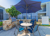 Thumbnail 36 of 40 - A patio with a table, chairs and an umbrella.