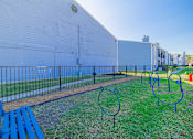 Thumbnail 30 of 40 - A white building with a blue bench in front of it.