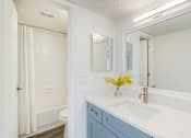 Thumbnail 5 of 19 - A white bathroom with a white sink and a white toilet.
