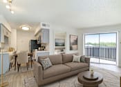 Thumbnail 1 of 19 - A living room with a couch, chairs, and a coffee table.