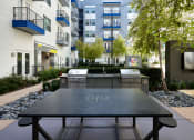 Thumbnail 10 of 24 - an outdoor table with two grills in front of an apartment building