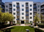 Thumbnail 5 of 24 - an exterior view of an apartment building with a lawn