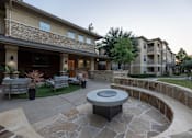 Thumbnail 18 of 39 - Stone patio with a firepit at Woodbridge Villas Apartments, Sachse