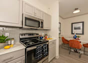 Thumbnail 4 of 39 - Kitchen with a black stove at Woodbridge Villas Apartments, Texas