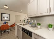 Thumbnail 3 of 39 - Kitchen with white cabinets at Woodbridge Villas Apartments, Sachse, 75048