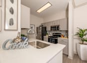 Thumbnail 5 of 39 - Kitchen with white countertops at Woodbridge Villas Apartments, Sachse, TX