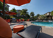 Thumbnail 16 of 39 - Pool area with a sun lounger at Woodbridge Villas Apartments, Texas