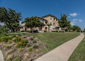 Thumbnail 36 of 39 - Apartment complex with a walkway at Woodbridge Villas Apartments, Sachse, TX, 75048