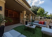 Thumbnail 11 of 39 - Patio with a grey couch at Woodbridge Villas Apartments, Sachse, TX, 75048