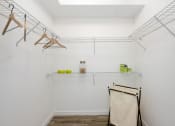Thumbnail 21 of 66 - room with white walls and a white closet with hanging racks and a shelf with towels