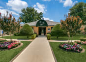 Thumbnail 33 of 36 - an exterior view of a brick building with a green awning and landscaping