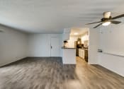Thumbnail 13 of 36 - an empty living room with a ceiling fan and a kitchen