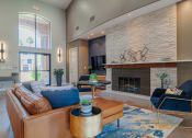 Thumbnail 46 of 54 - a living room with a leather couch and chair in front of a fireplace